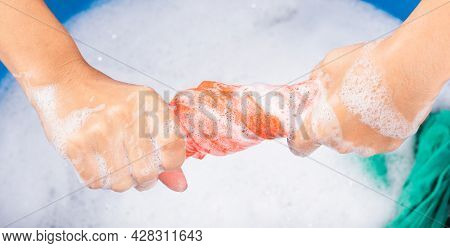 Closeup Young Asian Woman Use Hands Washing Color Clothes In Basin. Female Squeeze Wring Out Wet Fab