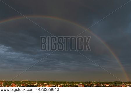 Rainbow Over Stormy Sky. Double Rainbow Over City With A Dramatic Sky In The Background. Gloomy Dark