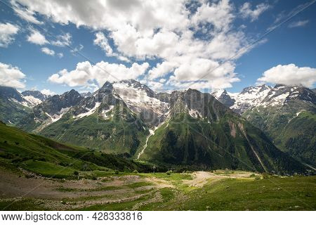 Mountain Landscape On A Sunny Summer Day. Blue Sky With Clouds. Russia, Dombay, Karachay-cherkess Re