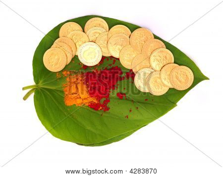Gouden munten gehouden op Betel blad samen met vermiljoen poeder