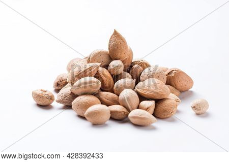 Almonds With Shell, Prunus Amygdalus Heaped On White Background