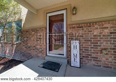 Entrance Of A House With Glass Storm Door And Signage Display