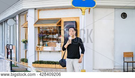 Asian Man In The Black T-shirt Holds The Bubble Ball Ice Milk Tea In Front Of The Shop On The Outdoo