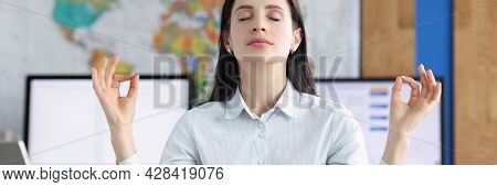 Calm Business Woman Doing Yoga Exercises In Workplace