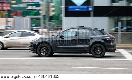 Fast Moving Black Porsche Macan Suv Rides On A City Road. A Car On Street In Motion. Overspeed In Ci