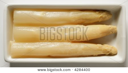 Espárragos en un plato blanco, tres piezas deliciosos