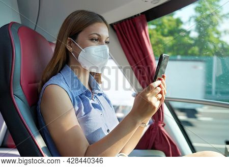 Side View Of Relaxed Woman With Kn95 Ffp2 Face Mask Using Smart Phone App. Bus Passenger With Protec