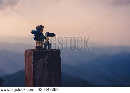 Silhouette Of Nature Photographer Taking Photos At Sunset In The Foggy Mountains. Illustrative Edito
