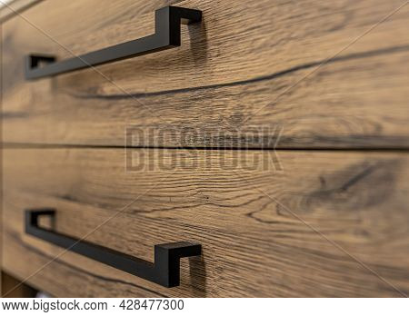 Wooden Chest Of With Drawers With Black Handles Close Up.