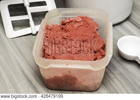 Homemade Cherry Ice Cream In A Plastic Container On The Table Next To An Ice Cream Spoon And An Ice 