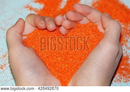 Sand Therapy Session, Orange Sand In The Shape Of A Heart In The Hands Of A Child, Autism Rehabilita