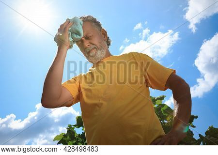 Senior Man With Towel Suffering From Heat Stroke Outdoors, Low Angle View