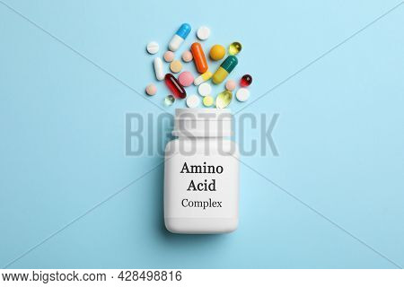 Plastic Bottle With Amino Acid Complex And Pills On Light Blue Background, Flat Lay