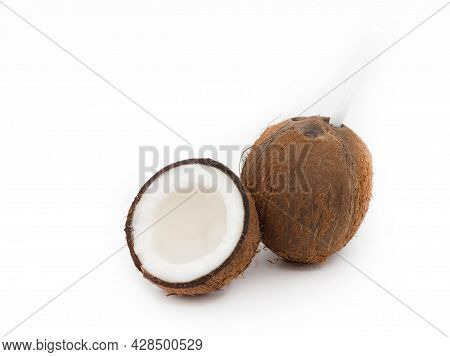 Exotic Whole Coconut Isolated On A White Background Next To Half Of The Fruit.