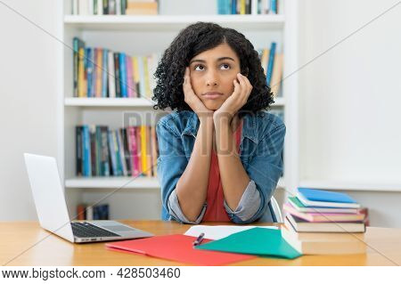 Concerned And Sad Female Student - Worried Peruvian Young Adult Woman At Desk At Classroom