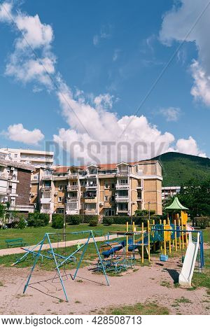 Playground In The Courtyard Of Five-storey Buildings Against The Backdrop Of Mountains