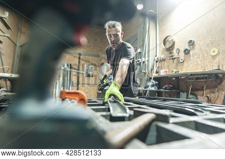 Worker Using Electric Wheel Grinding On Steel Structure In Factory