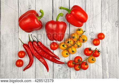 Red Chili Peppers, Bell Peppers And Cherry Tomatoes On A Gray Wooden Table.