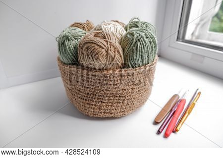 Yarn In A Knitted Basket On A White Background With Hooks. Yarn Of Different Colors. The Concept Of 