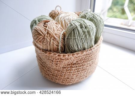 Yarn In A Knitted Basket On A White Background With Hooks. Yarn Of Different Colors. The Concept Of 