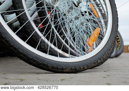 Wheels Of Bcycles Parking For Rent Close-up On Street Background