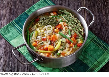Soupe Au Pistou, French Vegetable Bean Soup With Basil Sauce Pesto And Herbs In A Metal Pot On A Dar