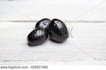 Closeup Of Organic Jamun Or Black Plum Isolated On Wooden Background, Also Known As Malabar Plum, Sy