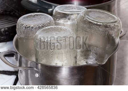 Glass Jars In The  Stainless Steel Pot During Steam Sterilization Over The Steamer For The Home Cann