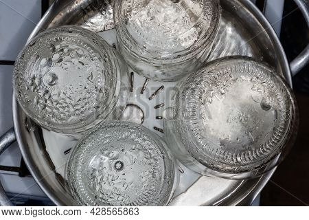 Glass Jars In The Stainless Steel Pot Over The Steamer During Steam Sterilization For The Home Canni