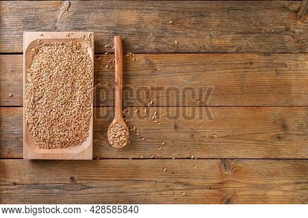 Wholegrain Uncooked Raw Spelt Farro On Wooden Plate On The Wooden Table