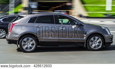 Moscow, Russia - July 2021: Gray Color Cadillac Srx Second Generation In Fast Motion On The Street