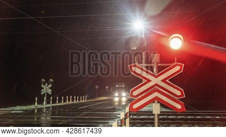 Train Crossing Gates Closed At Night. Train Grade Crossing With Blinking Or Flashing Lights While Tr