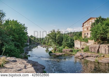 Big House With Red Roof And River Flowing In The Buky Canyon, Buki Village, Ukraine. Wonderful River