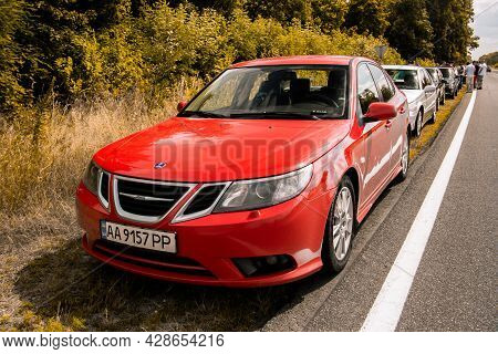 Chernigov, Ukraine - July 24, 2021: Saab Cars On The Road. Red Saab 9-3 Car On The Background Of Tre