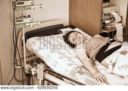 A Pregnant Woman Gives Birth In A Hospital With A Drip And A Ctg Machine. A Woman On A Clinic Bed Du