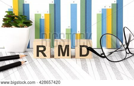 Rmd Word Written On Wood Block With Chart, Glasses And Pencils