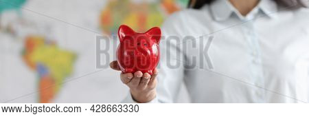 Young Smiling Woman Holding Red Pig Piggy Bank On Background Of World Map