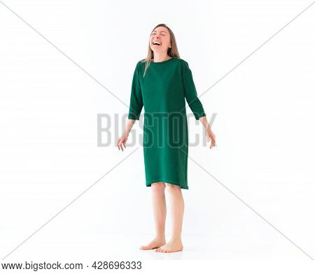 Young Happy Overjoyed Brunette Woman In Green Casual Dress Standing Barefoot Bursting Into Loud Laug