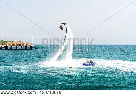 An Extreme Water Sport. A Guy Does Flip Tricks On A Water Flyboard. Extreme Vacation At The Sea.