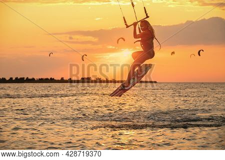 Young Woman Professional Kiter Performs A Difficult Trick In The Air On A Beautiful Background Of Th