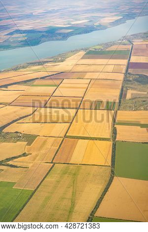 Land View Through The Airplane Window. Fields, Roads, Rivers From A Bird's Eye View. Porthole. Look
