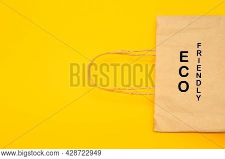 Eco Friendly Text On Shopping Bag.yellow Background, Top View Copy Space.