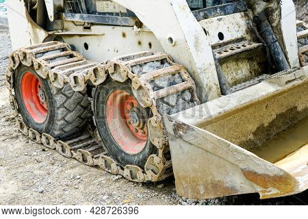 Skid Loader Or Bobcat With Metal Tracks On Rubber Tires