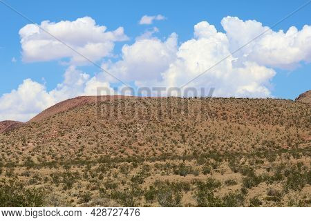 Cumulus Clouds Above The High Desert Plateau On Arid Badlands Covered With Sage Plants And The Creos