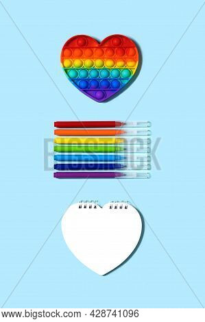 Back To School Concept. Popular Silicone Anti-stress Push Pop Fidget Toy Pop It Rainbow Colors, Felt
