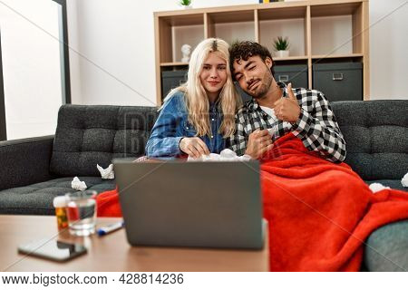 Young ill couple having medical teleconsultation using laptop at home.