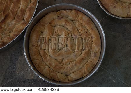 Baked Homemade Traditional Greek Cheese Twist Pie In Three Iron Oven Pan With Filo, Spinach, Mizithr