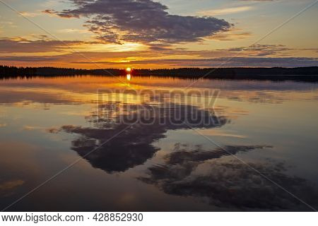 Picturesque Morning Sunrise With The Rising Sun And The Reflection Of Colorful Sky And Clouds On The