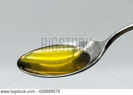 Extra Virgin Olive Oil In A Silver Spoon Isolated On White Background
