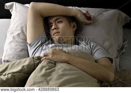 Depressed Young Asian Man Lying In Bed Cannot Sleep From Insomnia